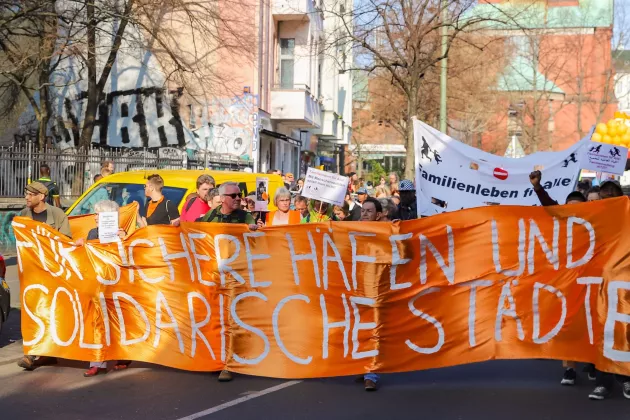 Demonstration in Berlin: Orangefarbener Banner mit der Aufschrift 