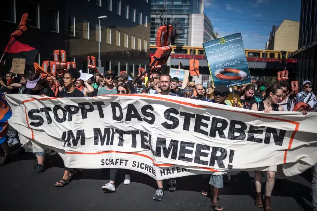 Demonstration in Berlin, auf einem großen Banner steht 