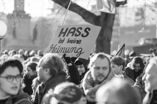 Schwarz-weiß Foto einer Demonstration, bei der ein Schild mit der Aufschrift 