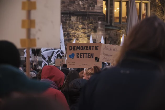 Auf einer Demonstration wird ein Schild mit der Aufschrift 