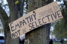 Ein Schild mit der Aufschrift "Empathy should not be selective", befestigt an einem Baum