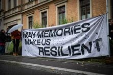 Auf einer Kundgebung zum Gedenken an die Opfer des Anschlags von Halle 2019 ist ein großes Transparent mit folgender Aufschrift zu sehen: May Memories Make Us Resilient.