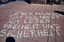 Mit Kreide auf Asphalt steht in Großbuchstaben: Jeder Mensch hat das Recht auf Leben, Freiheit und Sicherheit