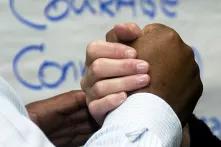foto eines Handschlags im Hintergrund das Wort Courage