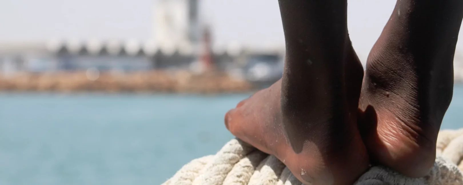 Im Vordergrund zwei Füße, im Hintergrund das Mittelmeer