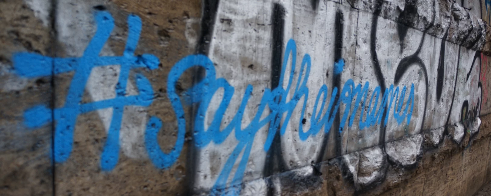 Hauswand mit blauem Schriftzug #Saytheirnames