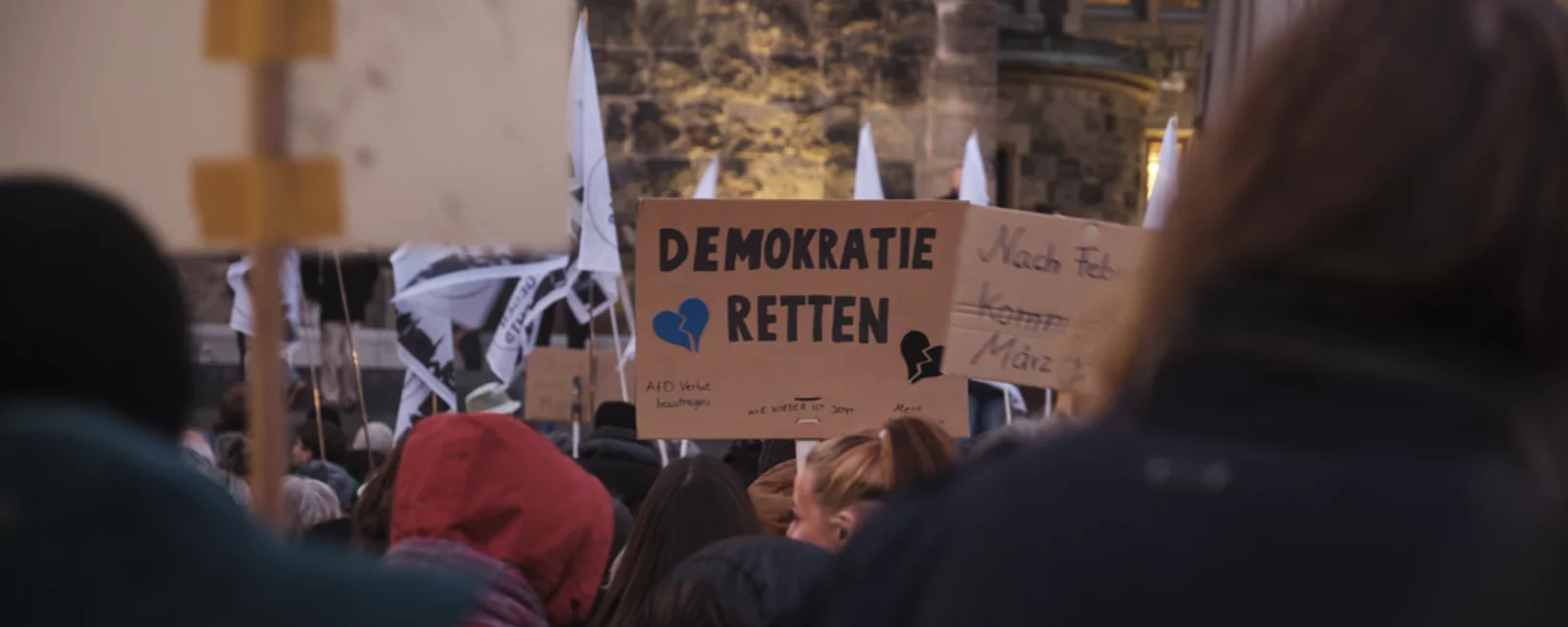 Auf einer Demonstration wird ein Schild mit der Aufschrift 