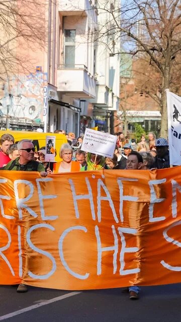 Demonstration in Berlin: Orangefarbener Banner mit der Aufschrift "Sichere Häfen und solidarische Städte"