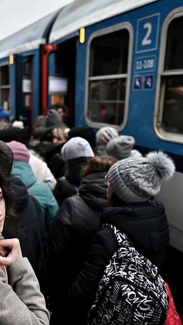 Ukrainische Geflüchtete stehen an einem Bahnsteig in Przemyśl und sind dabei, in einen Zug einzusteigen