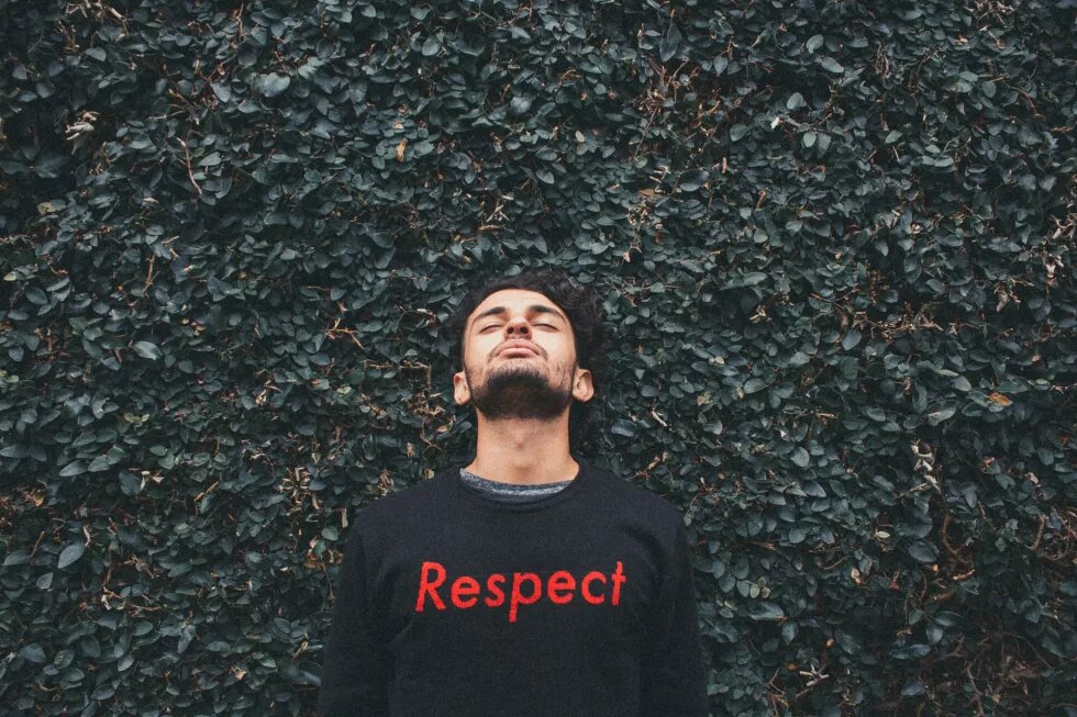 Person trägt Pullover mit Aufschrift "Respect"