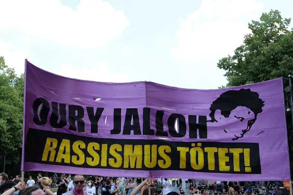 Bei einer Black Lives Matter Demonstration in Berlin 2020 wird ein großes Transparent hochgehalten mit der Aufschrift "Oury Jalloh - Rassismus tötet!"