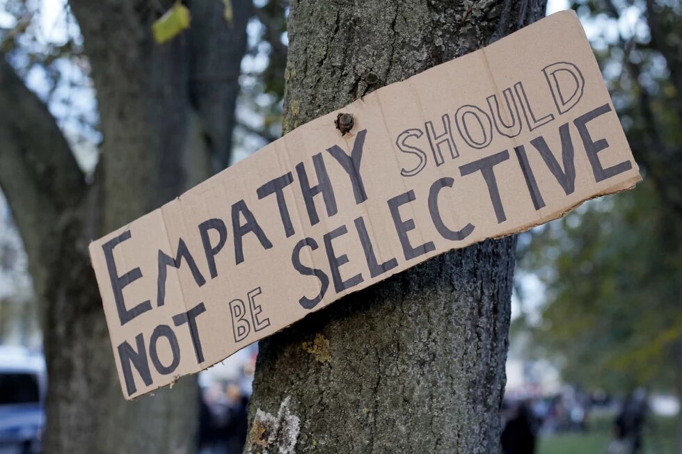 Ein Schild mit der Aufschrift "Empathy should not be selective", befestigt an einem Baum