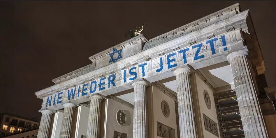 Das Brandenburger Tor in Berlin, auf dem "Nie wieder ist jetzt!" projiziert ist.