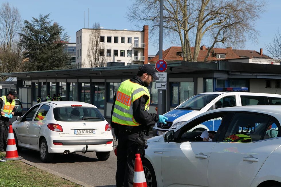 Grenzkontrollen von Ankommenden auf der deutschen Seite der Europabrücke zwischen Straßburg und Kehl am 16. März 2020, zu sehen sind zwei Polizeibeamte, die die Fahrer*innen zweier Autos kontrollieren