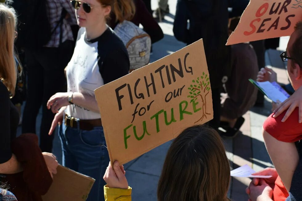 Auf einer Demonstration wird ein Schild mit der Aufschrift "Fighting for our Future" hochgehalten