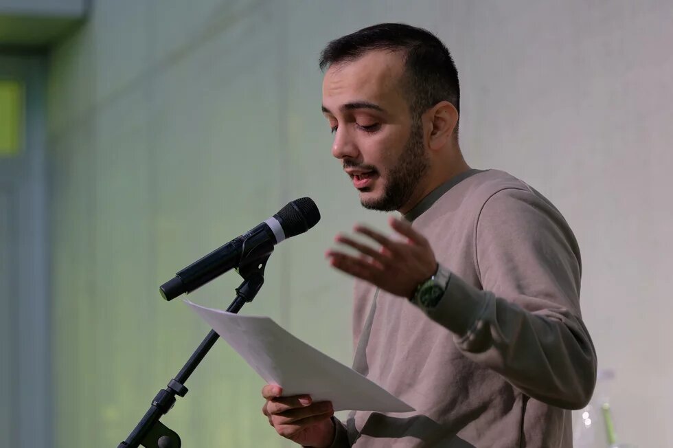 Ali Alzaeem liest sein Gedicht bei einer Veranstaltung der Heinrich-Böll-Stiftung vor