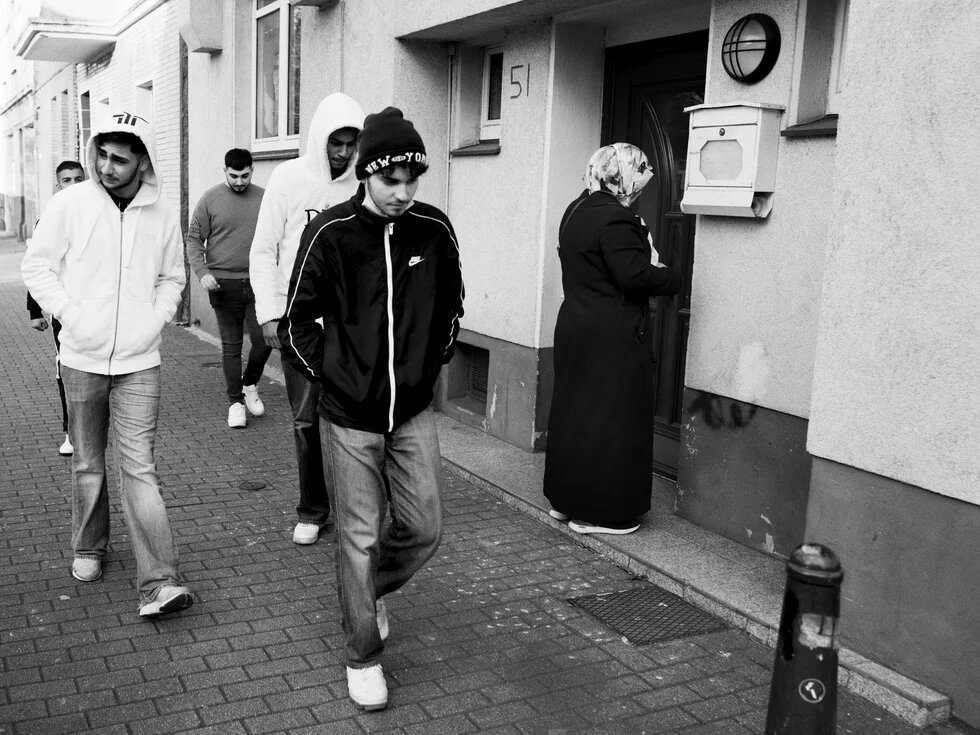 Eine Gruppe Jugendlicher läuft eine Straße entlang