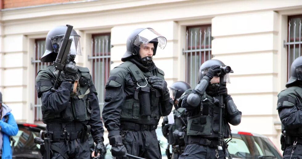 Drei behelmte und bewaffnete Polizisten bei Protesten gegen einen Naziaufmarsch in Leipzig am 18.03.2017