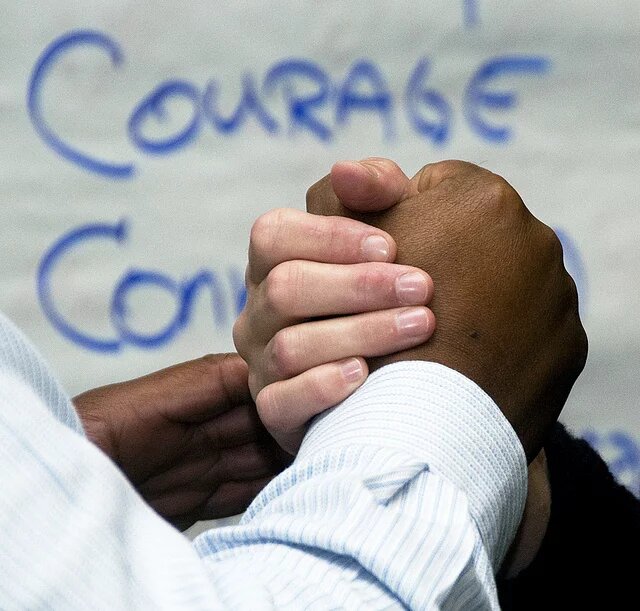 Wirtschaftliche Potentiale von Migration & Integration Foto eines Handschlags im Hintergrund das Wort Courage