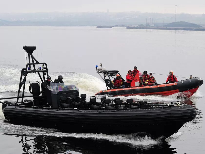 The Royal Canadian Mounted Police Emergency Response Team (front) and the Canadian Coast Guard patroling the surroundings of a mock migrant vessel in Sydney