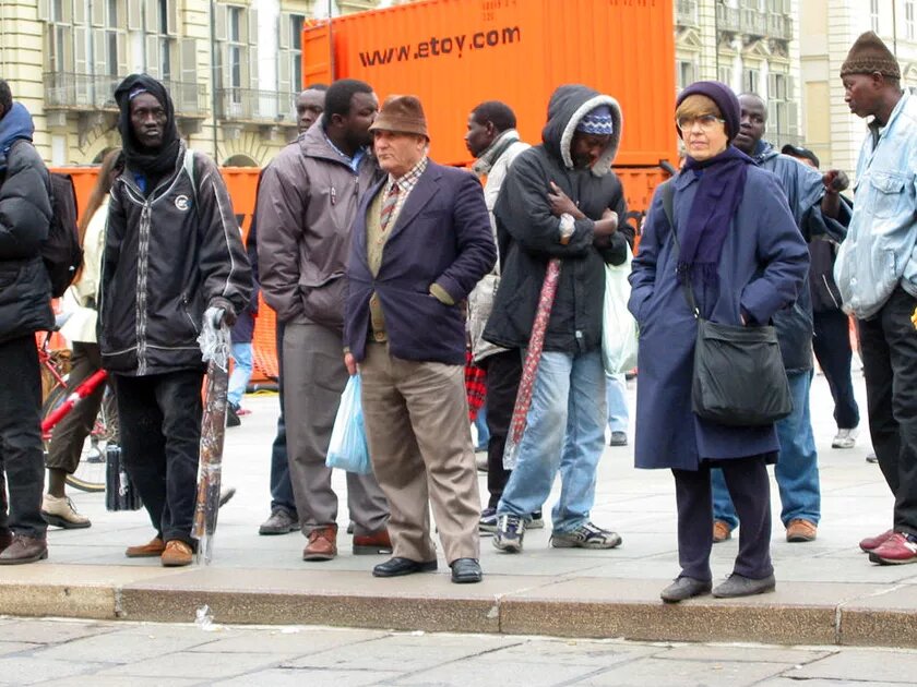 Migrants from Western Africa selling umbrellas on the central plaza in Torino, Italy