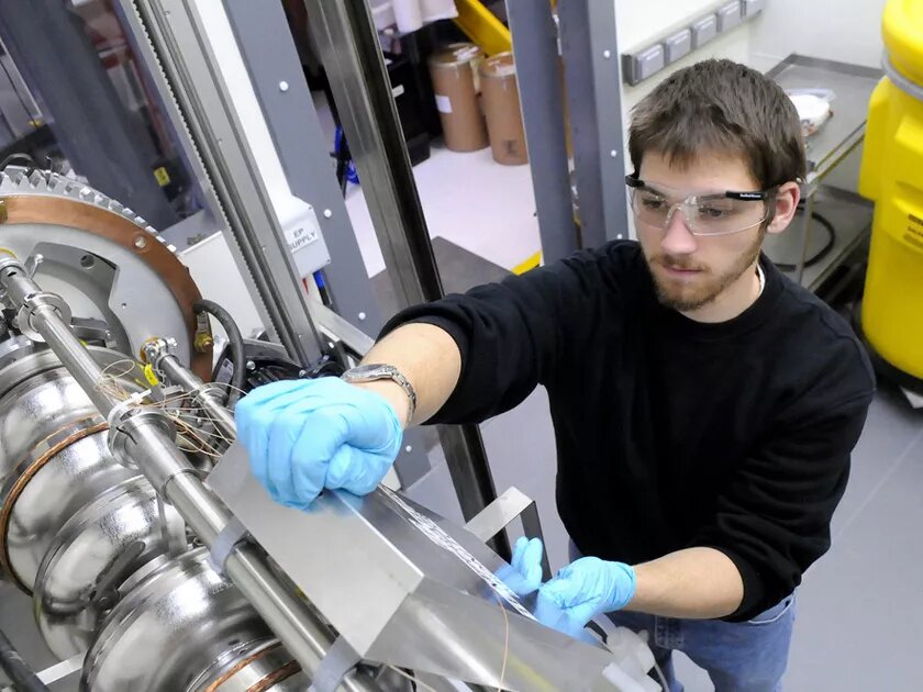 Engeneering assistant working on a highly technical device used to accelerate charged particles