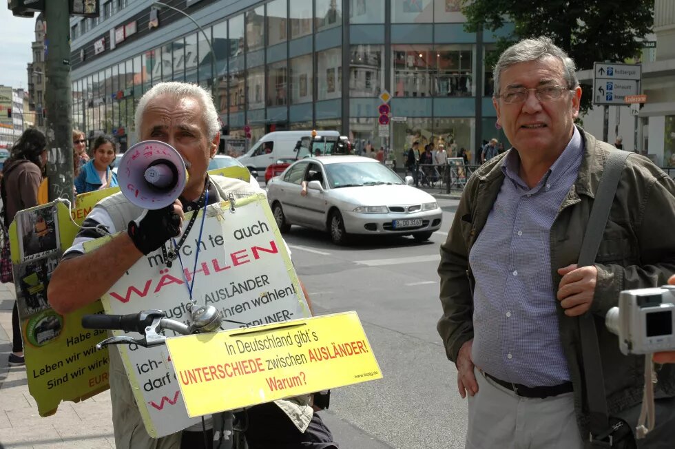 Wahlrecht für alle Mann mit Schild "Ich möchte auch wählen", zweiter Mann daneben
