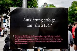 Plakat mit Aufschrift "Aufklärung erfolgt im Jahr 2134" und kleingedrucktem Erklärungstext, dass ein NSU-Bericht in Hessen für 120 Jahre weggesperrt werden sollte