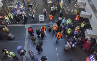 Berliner Hauptbahnhof: Geflüchtete aus der Ukraine werden von Unterstützer:innen in orangenen und gelben Warnwesten in Empfang genommen