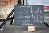 Schild mit Aufschrift "Oury Jalloh was burnt alive by German Police #SayHisName!"