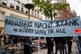 Demobanner: "Rassismus macht krank: ein besseres Leben für alle." Demobanner: "Rassismus macht krank: ein besseres Leben für alle."