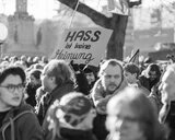 Schwarz-weiß Foto einer Demonstration, bei der ein Schild mit der Aufschrift "Hass ist keine Meinung" hochgehalten wird