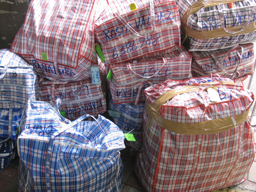 Bags of labour migrants on their way to the shipping container Bags of labour migrants on their way to the shipping container